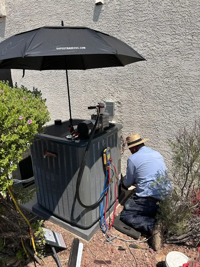 HVAC technician performing outdoor AC maintenance in Bixby